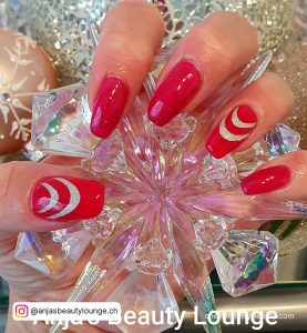 Red Nails With Silver Ring Finger Holding A Crystal