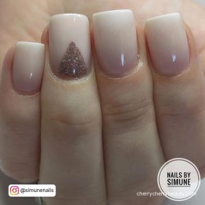Short French Acrylic Nails In Nude Shade And Glitter Pyramid On Ring Finger