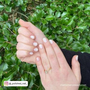 Short Matte White Nails In Front Of Plants