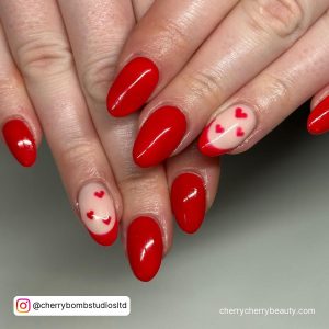 Short Round Tip Red Nails With One Nude And Red French Tip Nails With Small Red Hearts