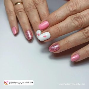 Short Square Tip Nails With A Pink Glitter Nail And A White Nail With A Pink Heart