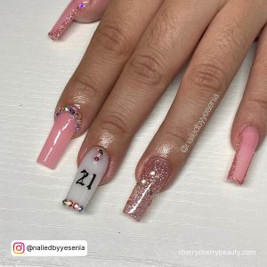 Square Tip Light Pink And White Nails With A Pink Glitter Nail And 21 Written In Black