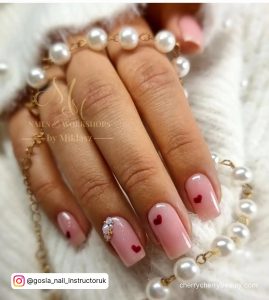 Square Tip Pink Nails With A Simple Red Heart On Each Nail And A Cuticle Gem