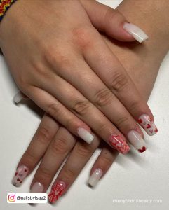 Square White Nails With Red Confetti Heart Designs And One Feature Pink Nail Design