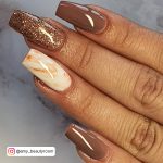 White And Brown Nails With Glitter On One Nail