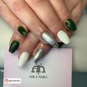 White And Dark Green Nails With Silver Nail Paint On One Finger