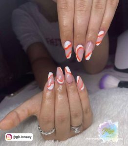 White And Orange Marble Nails On A Table