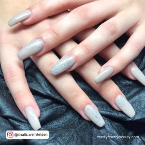 White Gray And Silver Nails On A Black Surface