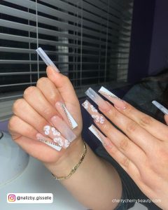 White Nail Polish With Rhinestones And Flowers
