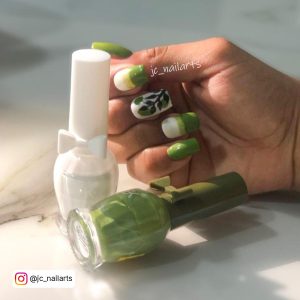 White Nails With Green Tips And Stem Design On One Finger