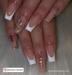 White Nails With Rhinestones And Glitter Near The Nail Bed