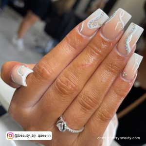 White Square Tip Nails With Nude And White Ombre And White And Silver Glitter Swirl Designs