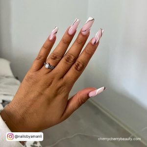 White Swirl Design Nails In Front Of A Wall