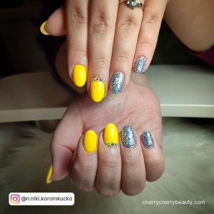 Yellow Acrylic Nails With Silver Glitter In Almond Shape