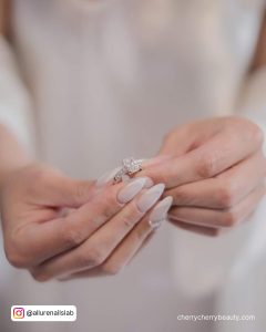 Adorable Almond French Tip Acrylic Nails Holding Diamond Ring