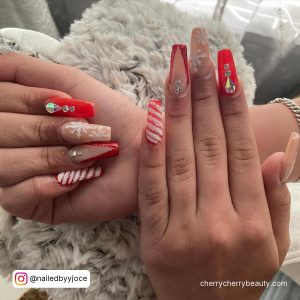 Baddie Christmas Acrylic Nails Red With Rhinestones Over Grey Surface