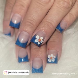 Blue Glitter French Tip Acrylic Nails With Flower Design Over White Fur
