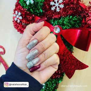 Christmas Silver And Red Glitter Acrylic Nails With Christmas Tree In Background