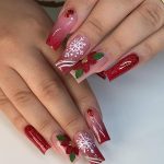 Christmas-Themed Red Acrylic Nails Designs On White Surface