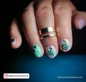 Cute Acrylic Nail Ideas For Summer With Flowers And Gold Flakes On Blue Surface