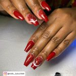 Deep Red Glitter Acrylic Nails On White Surface