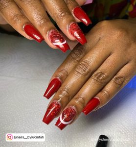 Deep Red Glitter Acrylic Nails On White Surface