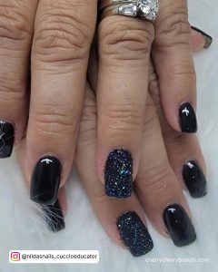 Dreamy Black Glitter Acrylic Nails On White Surface