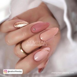 Elegant Pink And Gold Acrylic Nail Ideas For Christmas On White Surface