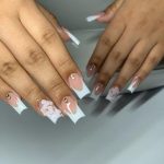 Flowery Short Square Acrylic Nails French Top Design With Stones Over White Surface
