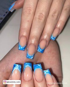 French Blue Marble Acrylic Nails Over White Surface