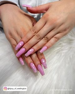 Gorgeous Acrylic Nails Designs For Summer With Glitters And Heart Design Laying On White Fur