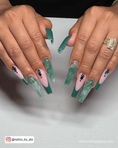 Gorgeous Emerald Green French Tip Acrylic Nails With Rhinestones And Marble Design Over White Surface
