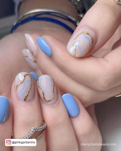 Gorgeous Nude And Blue Christmas Acrylic Nails With Glitter And Swirly Design