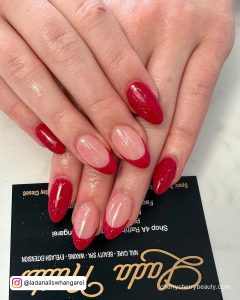 Hot Red Almond Acrylic Nails With French Tips Over Business Card