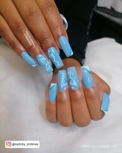 Light Blue Butterfly Nails Acrylic Over White Clothe