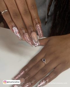 Light Pink Chrome Nail Polish With White Design On Two Fingers