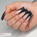 Long Black French Acrylic Nails Over White Surface