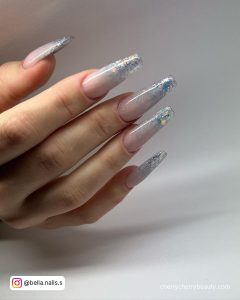 Long Pretty Silvery Glittery Acrylic Nails Over White Surface