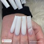 Long Simple White Acrylic Nails With Stones And Marble Design Over White Fur