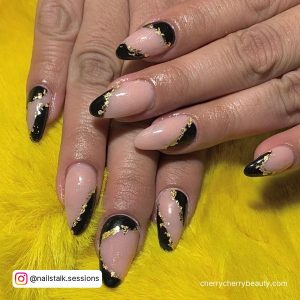 Nude And Black Almond Acrylic Nails With Gold Flakes Over Yellow Fur