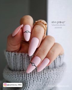 Pastel Pink Acrylic Nails With Black And White Design On Two Fingers