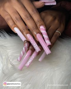 Pink And White Square Nails With Design On Two Fingers