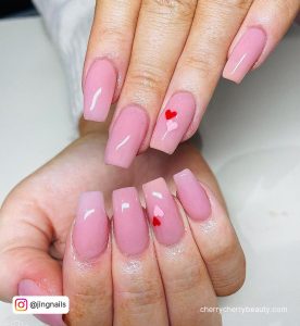 Pink Nails With Heart On Ring Finger In Red