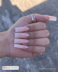 Pink Summer Ombre Acrylic Nails With Stones And Floor In Background