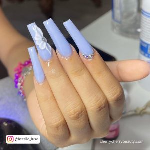 Pretty Pastel Blue Acrylic Nails With Flower On White Surface