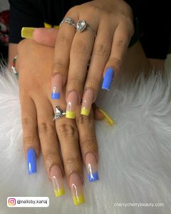 Pretty Yellow And Blue French Tip Acrylic Nails Over White Fur