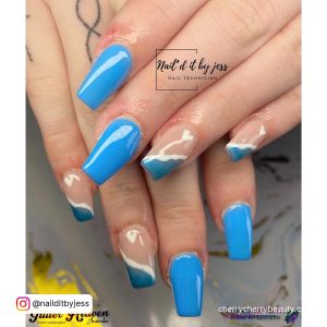 Short Light Blue Acrylic Nails With French Tips Over White And Gold Surface
