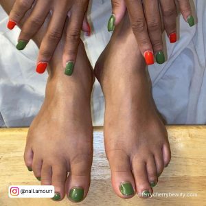 Short Orange And Green Fall-Themed Acrylic Nails And Toe Nails Over Wooden Surface