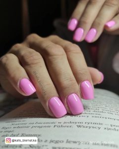 Short Pink Square Acrylic Nails On A Book