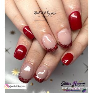 Short Red Glitter Tip Acrylic Nails Over White Surface